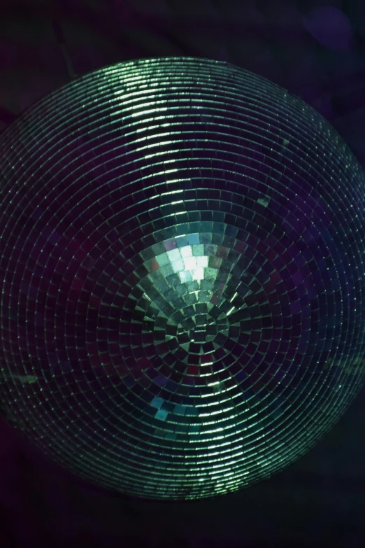 a circular pattern made of silver tiles on a black background