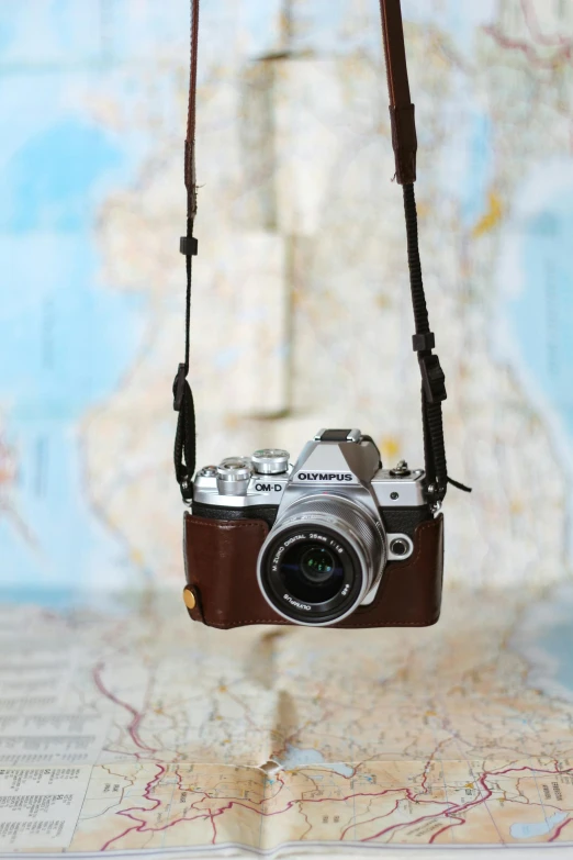 a camera with leather strap is hung on the map