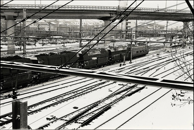 a black and white po of train tracks with a bridge