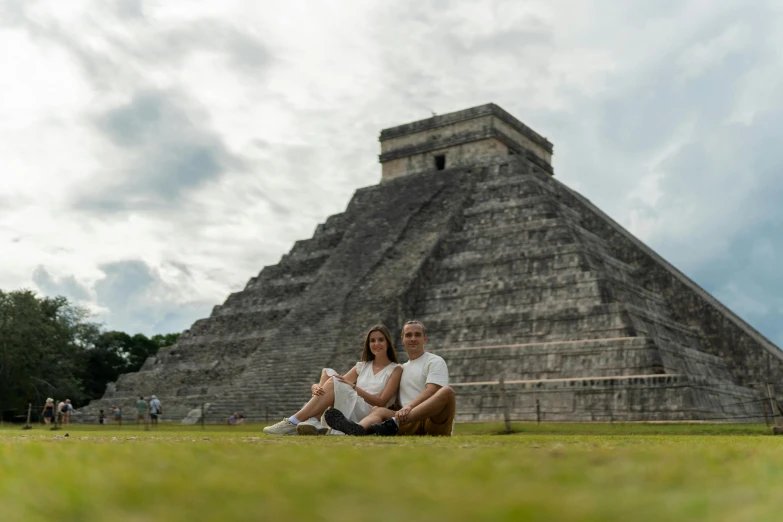 a couple poses in front of a pyramid