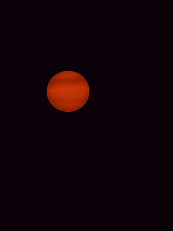 an orange object is seen in the dark sky