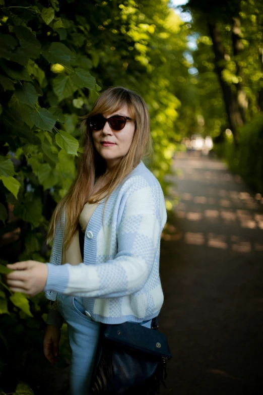 a lady that is walking down a tree lined path