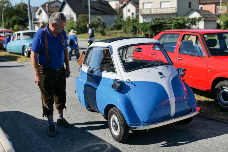 a man standing next to a small car