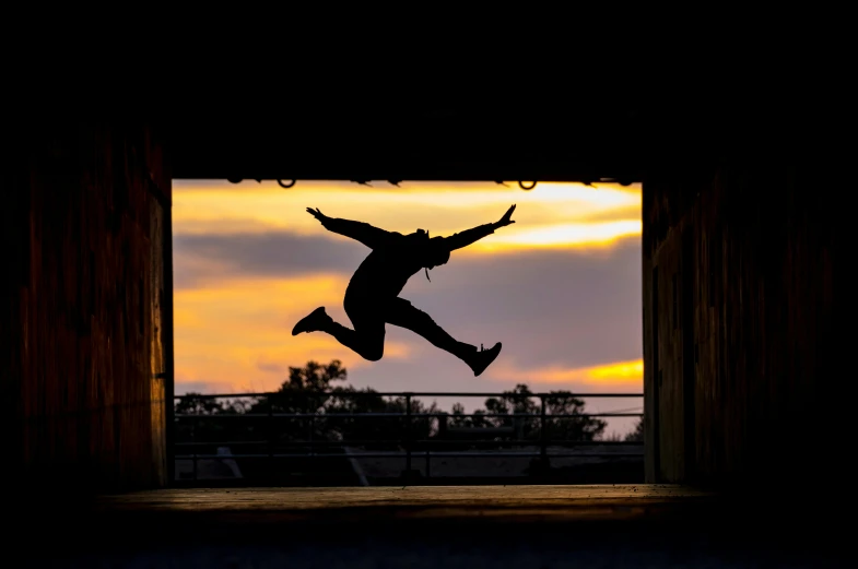 man jumping high into the air in front of sunset