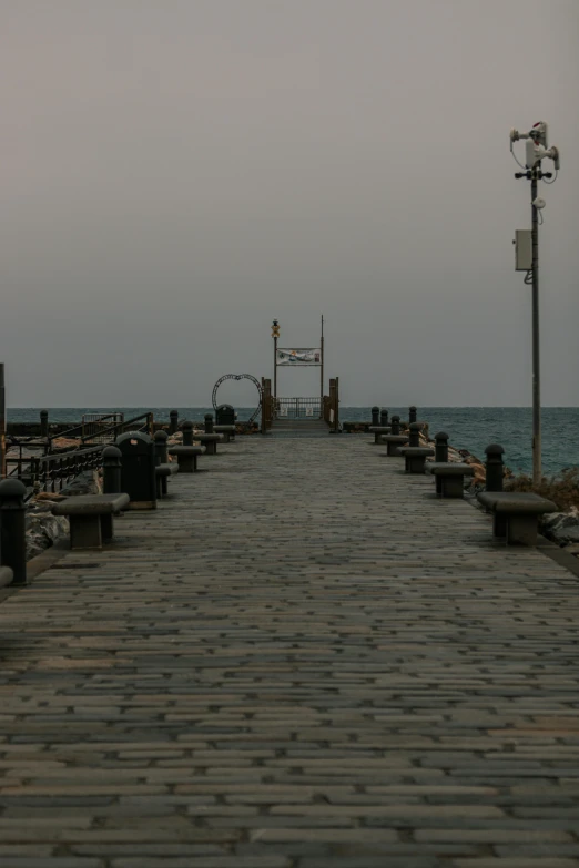 the boardwalk extends into an ocean from the shore