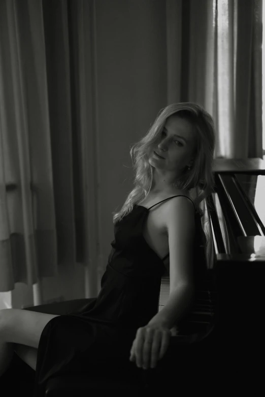 a woman sitting at the piano with her legs crossed