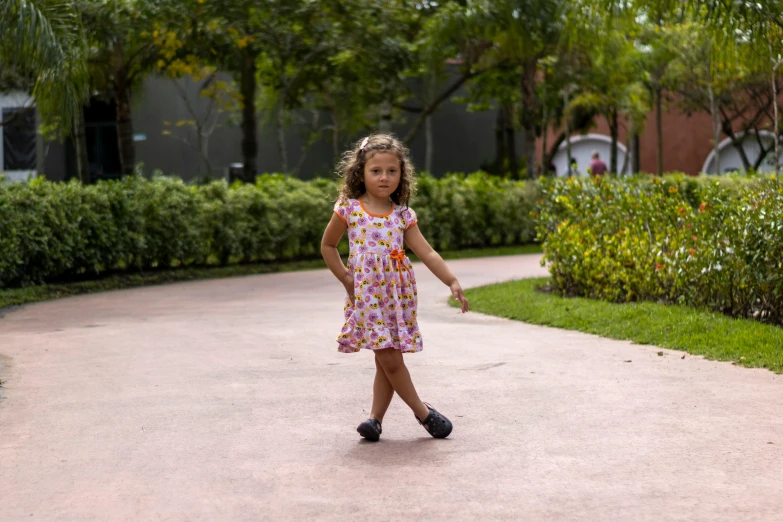 the little girl is holding an umbrella on the sidewalk