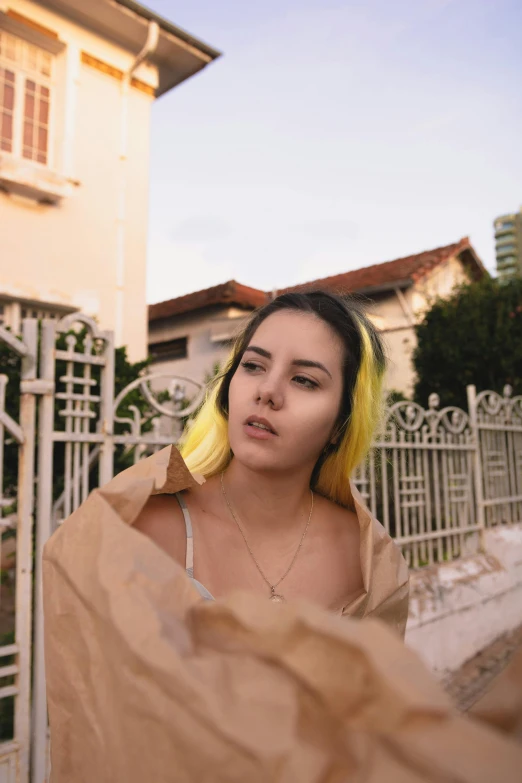 a girl covered by a brown blanket staring at the camera