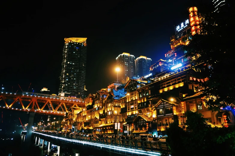 a large bridge across the water with illuminated city lights behind it