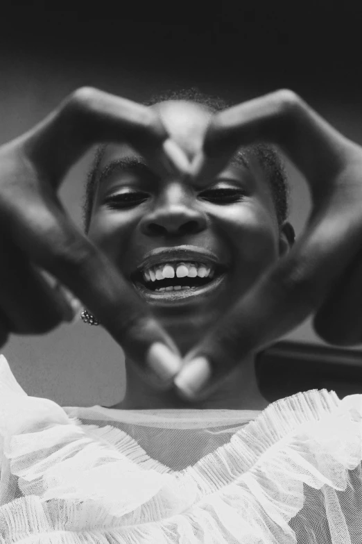 a woman making a heart in black and white