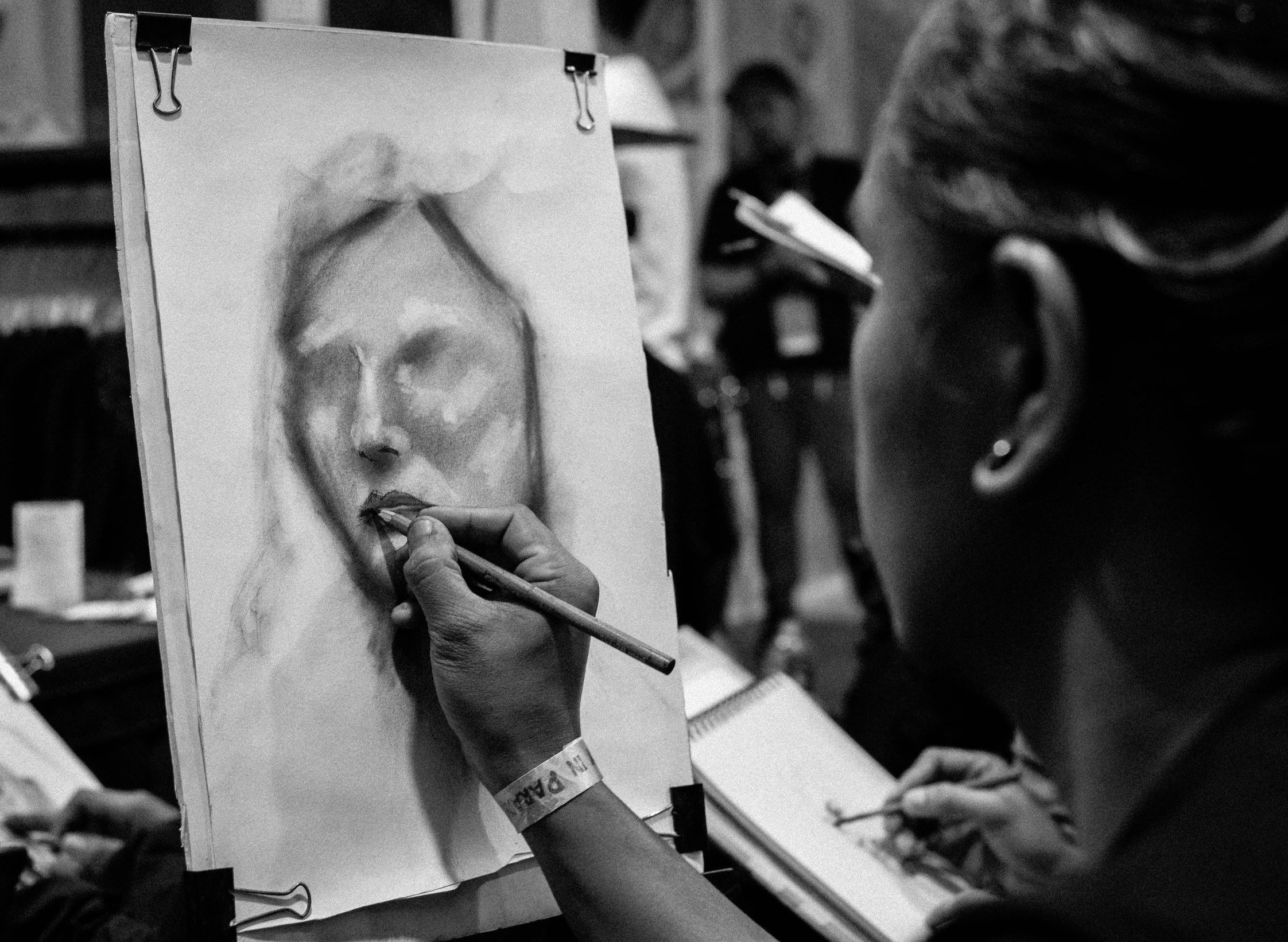 the artist draws soing on her paper and takes pictures of the face