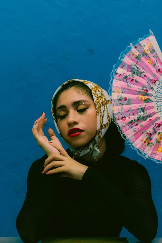 a woman with a lace head scarf holding an oriental umbrella