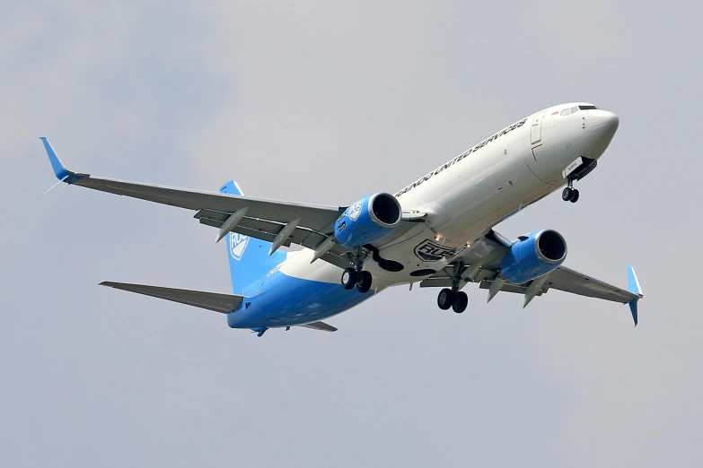 a large plane with its wheels down is flying through the air