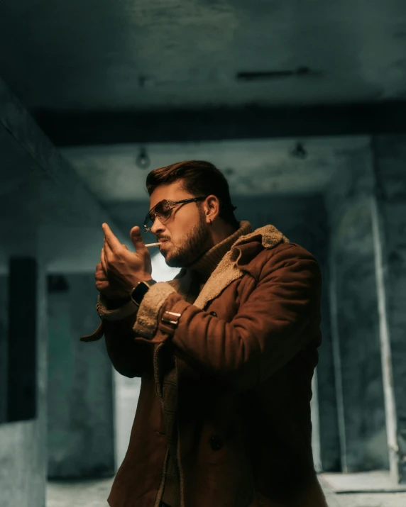 a man in a brown coat and glasses is holding soing