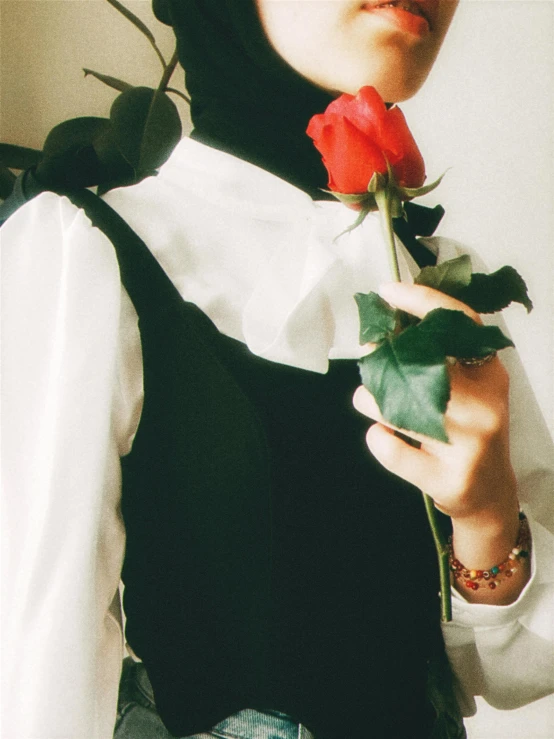 a man holding a rose with a white collar