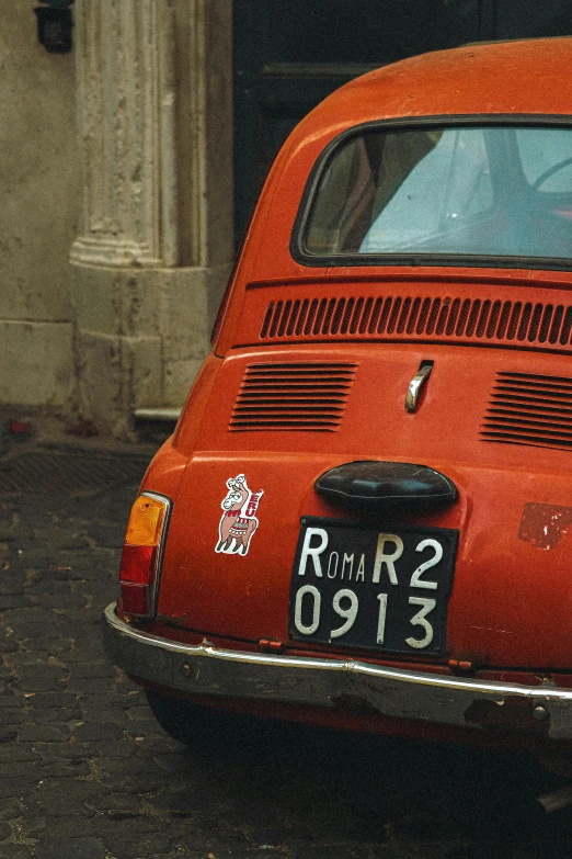 a old red car parked in front of a building