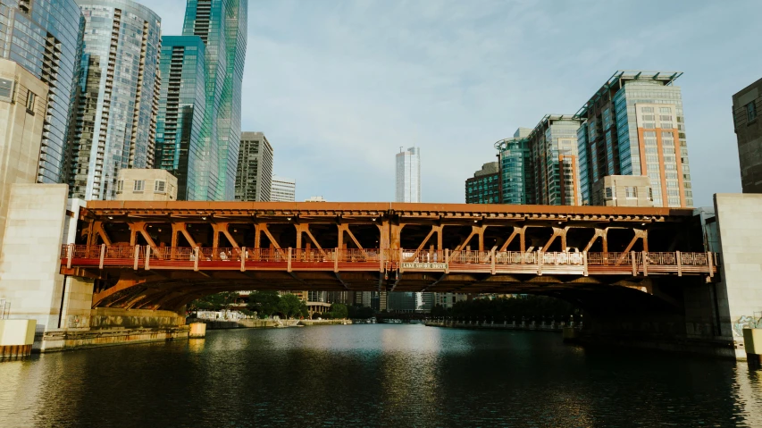 a bridge over a river in the city with tall buildings