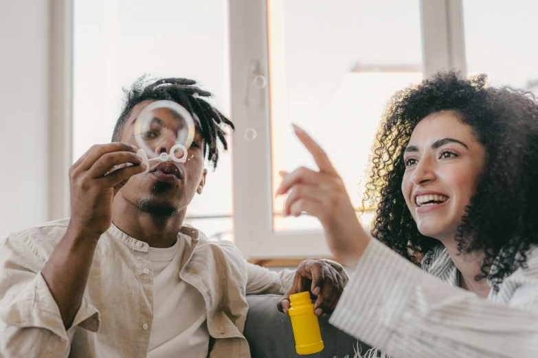 two adults blowing bubbles on the ceiling and smiling