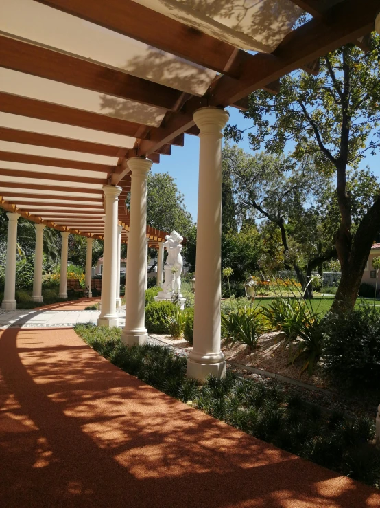 a walkway lined with columns and arches leads into the park