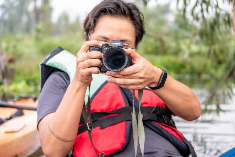 a person is holding a camera near the back of a boat