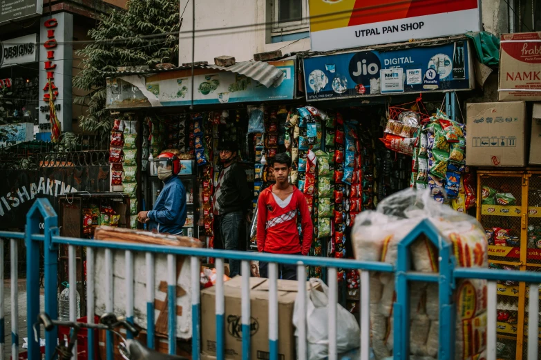 two men stand outside a store selling many products