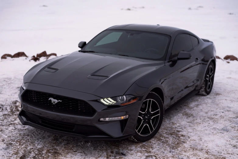 black sports car is parked on snow covered ground