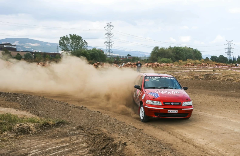 a car with a flag is on a dirt road