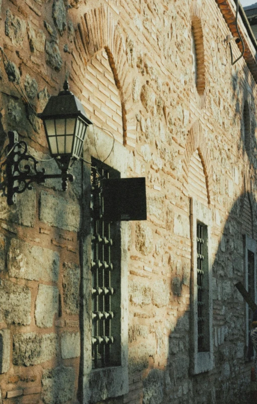 an old stone building has two lanterned windows on it