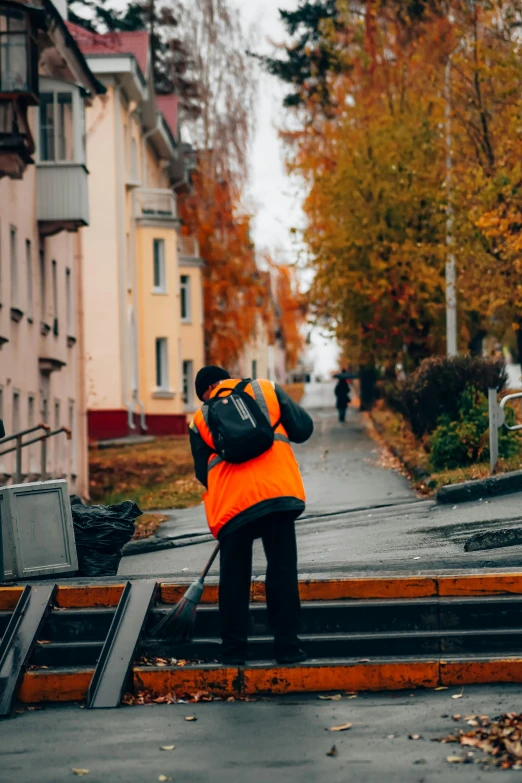 a man sweeping up a street with a broom