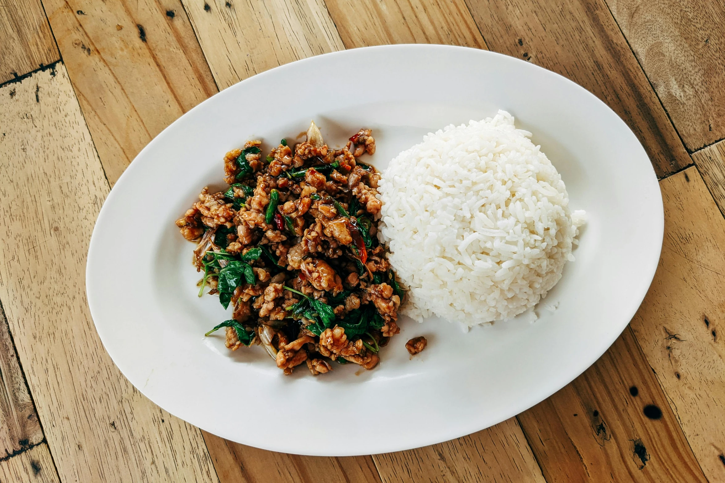 rice, meat and greens on a white plate