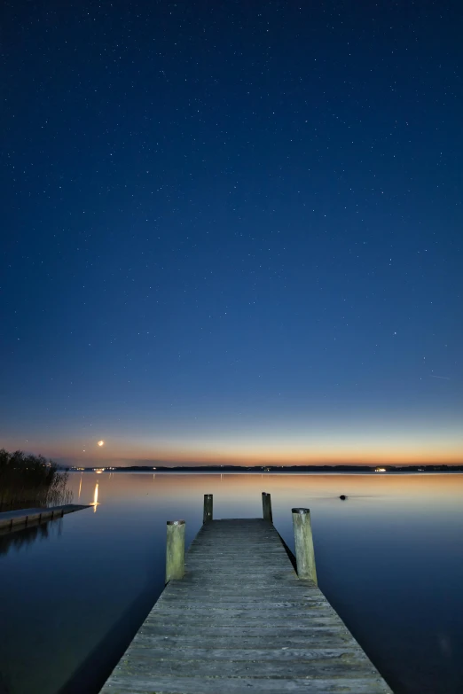 a long dock at night with stars in the sky