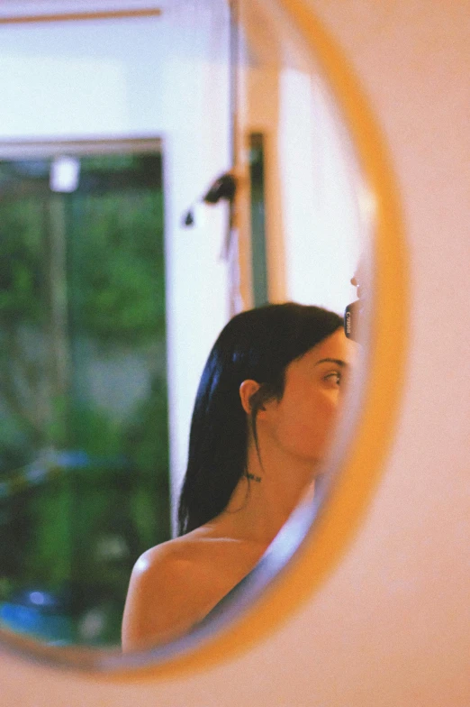 a woman is seen reflected in a mirror