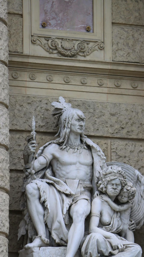 a statue is shown against a wall, with another figure behind it