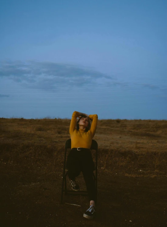 a woman sitting in a chair with her head on her hands