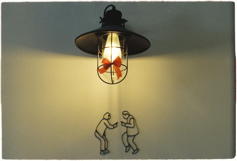 a wall lamp next to a man and a girl on it