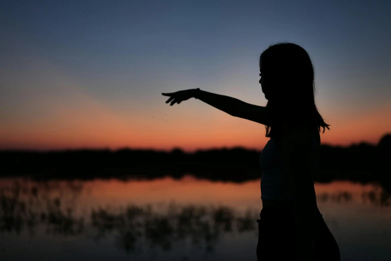 the woman is pointing to the sky with her arm