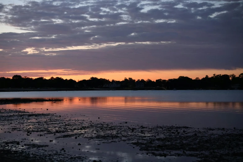 a plane flying over the lake at sunset