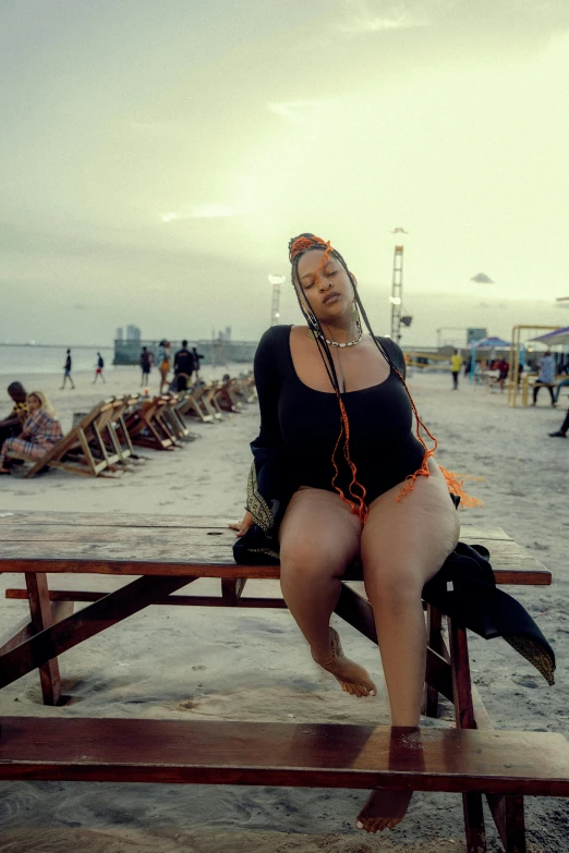 a woman sitting on a bench at the beach