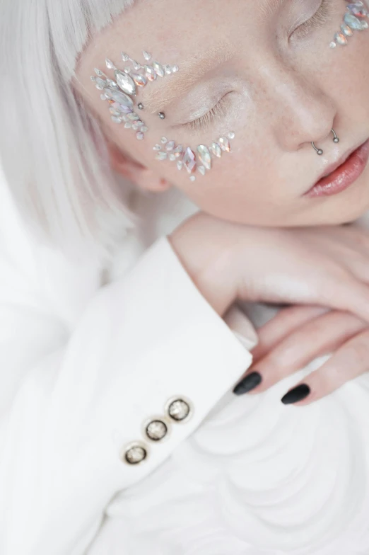 a woman with white hair wearing silver, glitter eye makeup