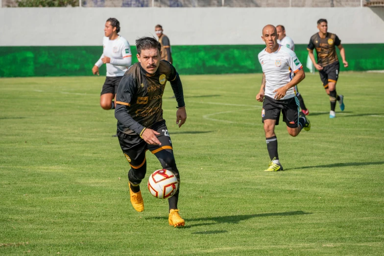 soccer players in black and white uniforms are playing on green grass