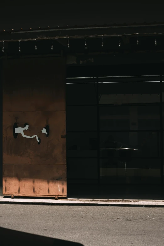 a fire hydrant sits on the side of a wall in front of a building