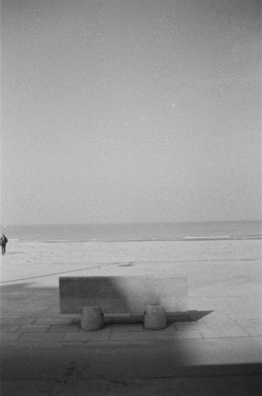 a black and white po of a bench on a beach