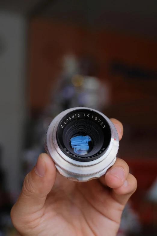 a person is holding a tiny lens device