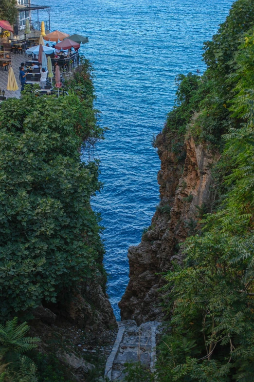 a body of water near a small cliff on a mountain