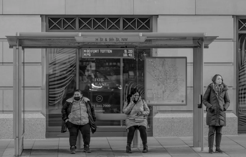 a black and white po of three people waiting at a train station