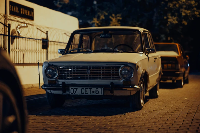 an older model car parked on the sidewalk