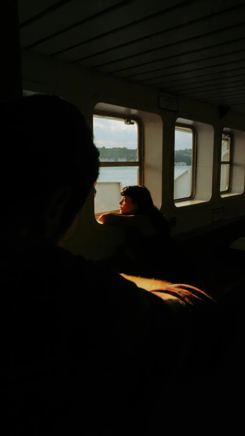 a man staring out a window at a body of water