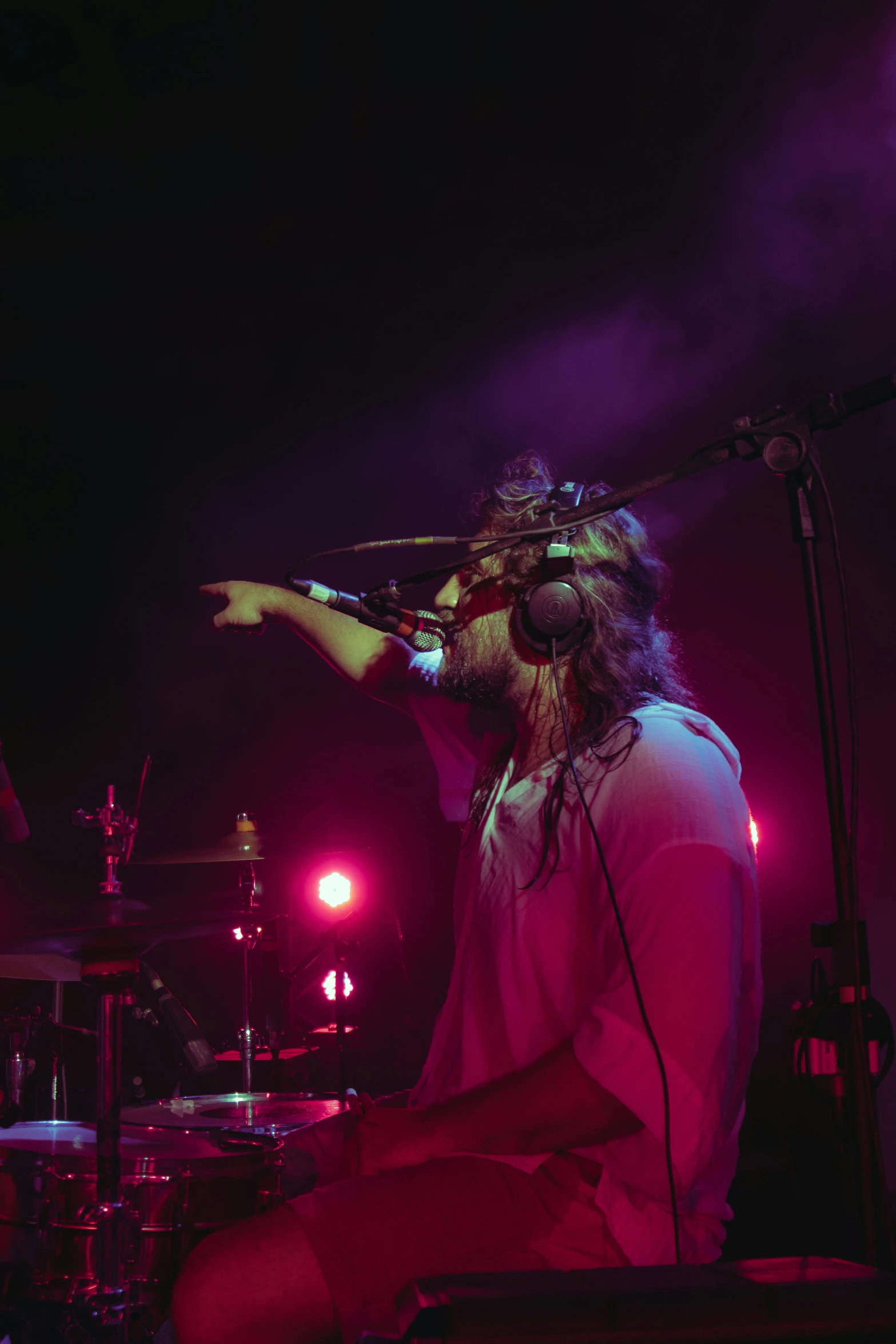 a man with headphones is playing drums in front of a microphone