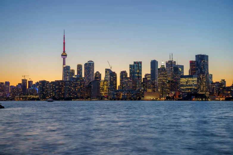 the skyline of toronto, canada is illuminated with bright yellow and red lights