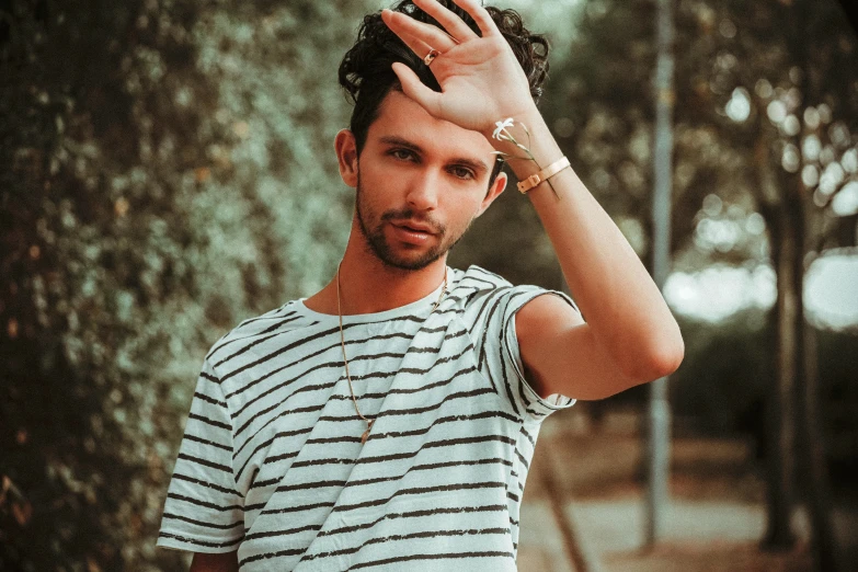 man putting on his hair while holding up his hands